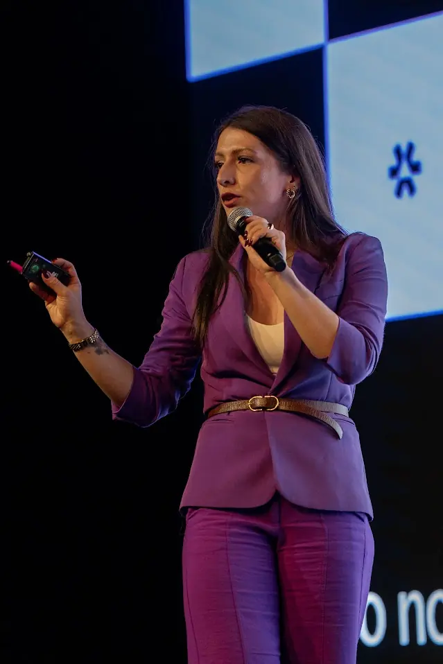Bell apresentando no palco com microfone.